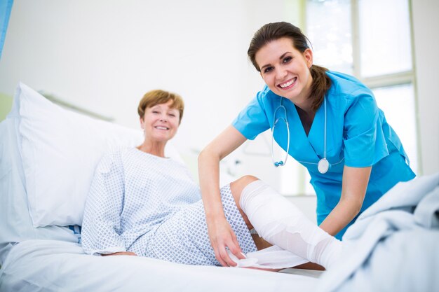 Nurse bandaging leg of patient