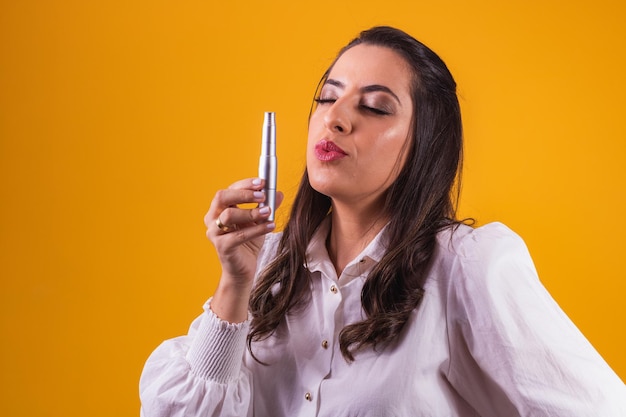 Nurse and beautician holding a dermapen for lip hydration on yellow background puckering lips