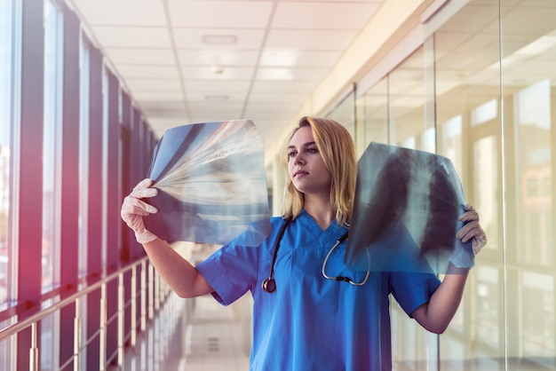 Nurse in a blue uniform checks for pneumonia in the xray film of lungs. covid19