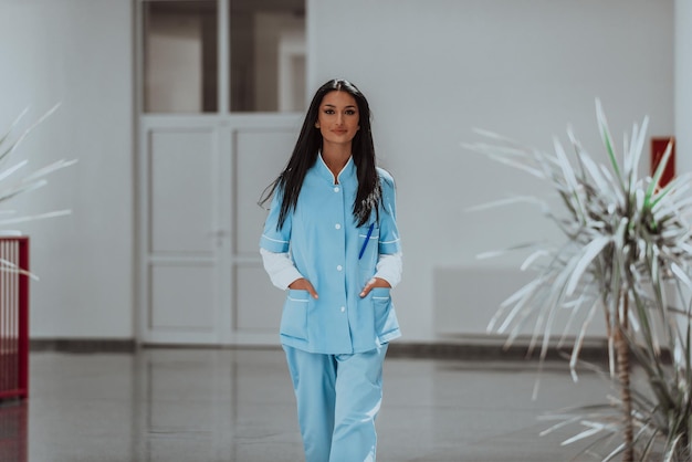 Photo a nurse in a blue uniform standing in the corridor of a modern hospital