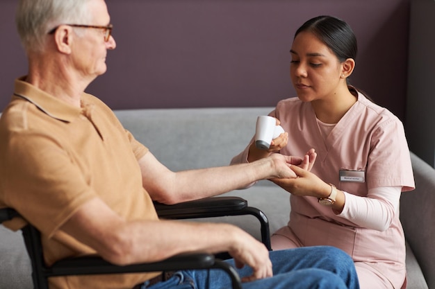 Nurse checking temperature of senior man