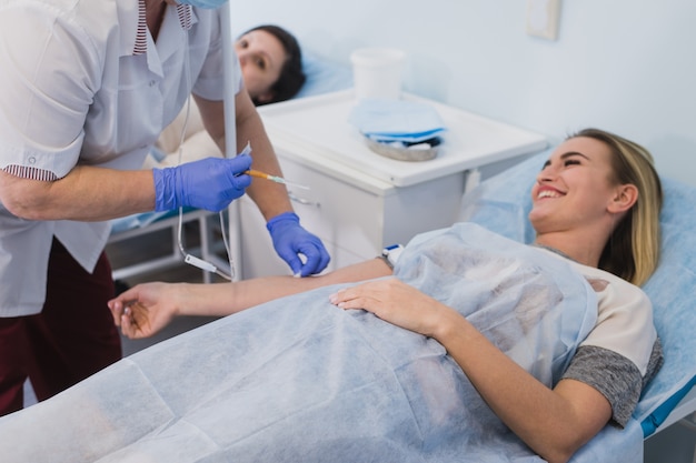 Nurse connecting an intravenous drip in hospital room