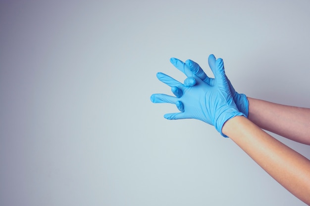 Nurse or cosmetologist putting on medical latex glove isolated. Copy space.