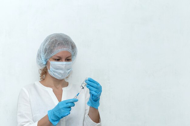 A Nurse dials the injection into the syringe, vaccination