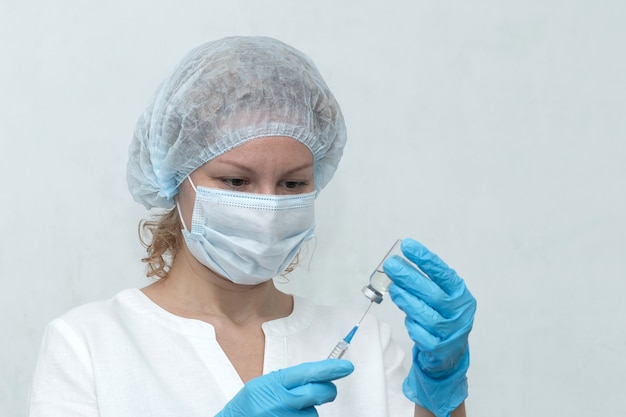 A Nurse dials the injection into the syringe, vaccination