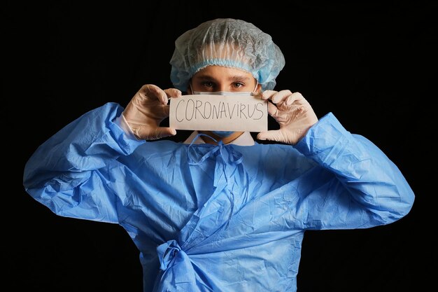 Медсестра-врач держит открытую карточку с надписью «Пандемия коронавируса COVID19 2022».