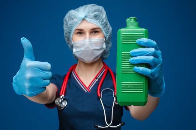 Nurse or doctor with a bottle of sanitizer and thumb up.