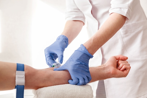 The nurse draws blood from a vein for test