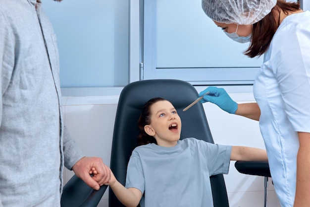 Photo the nurse examines the girl's throat