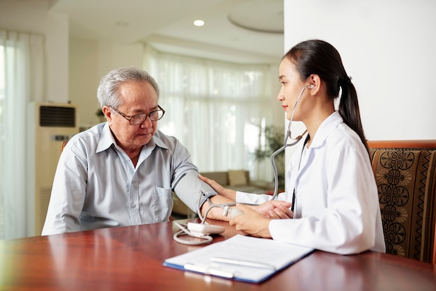 Nurse examining the patient at home