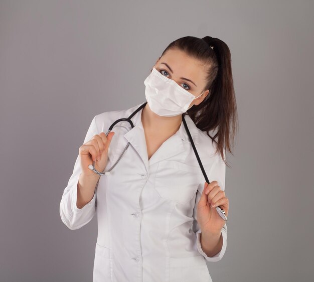 Nurse in gauze is against grey background