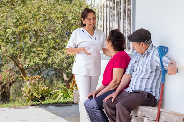 Nurse giving a talk on health care for the elderly during a home visit Attention for the elderly