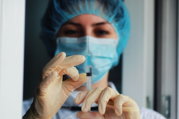 Nurse hands holding syringe and ampoule