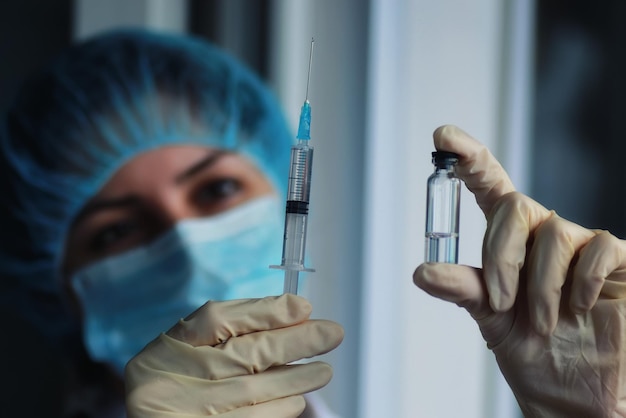 Nurse hands holding syringe and ampoule