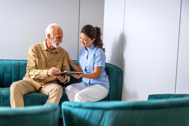 Nurse helping the patient to fill out medical questionnaire before visiting the doctor in hospital