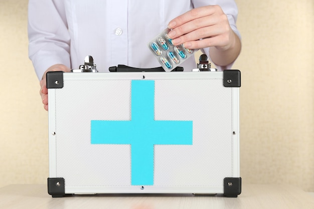 Nurse holding first aid kit close up