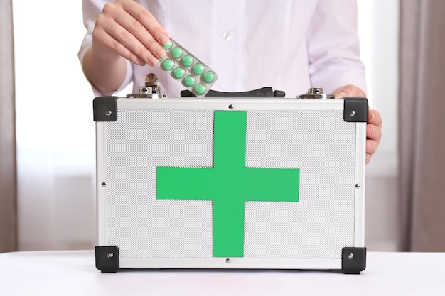 Nurse holding first aid kit in room