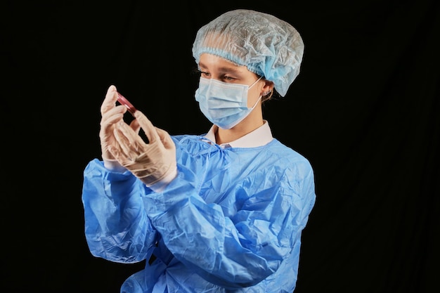 A nurse holds a test tube with a blood sample that is positive for coronavirus Pandemic COVID19