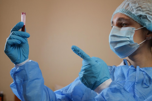 A nurse holds a test tube with a coronavirus positive blood sample 2019 nCoV pandemic