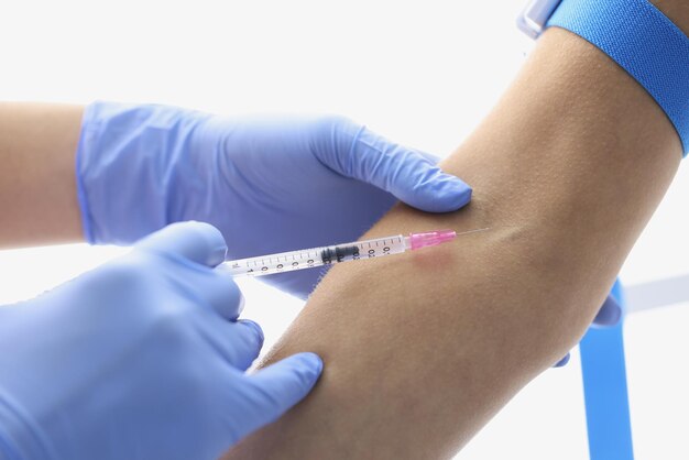 Nurse injects liquid medication in patients vein with needle