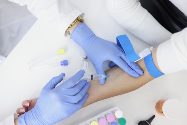 Nurse injects liquid medication in womans vein with needle