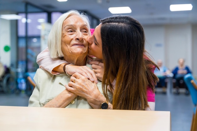 Nurse kissing a cute elder woman in a geriatric