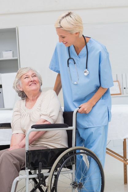 Nurse looking at senior patient sitting on wheelchair