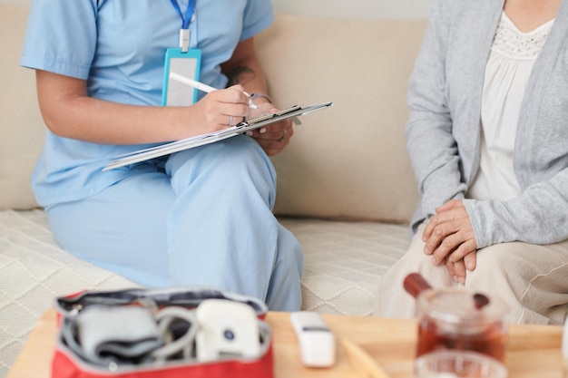 Nurse making notes during home visit