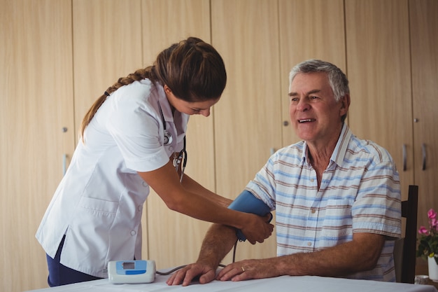 Nurse measuring the blood pressure of a senior man