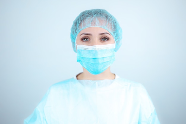 Nurse in a medical gown, mask on a white background