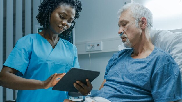 Photo a nurse and a nurse are looking at a tablet.