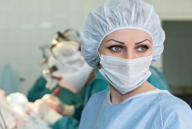 The nurse in the operating room looks into the distance