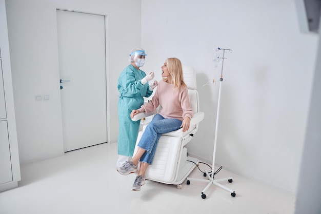 Nurse performing a pharyngeal swab in the woman