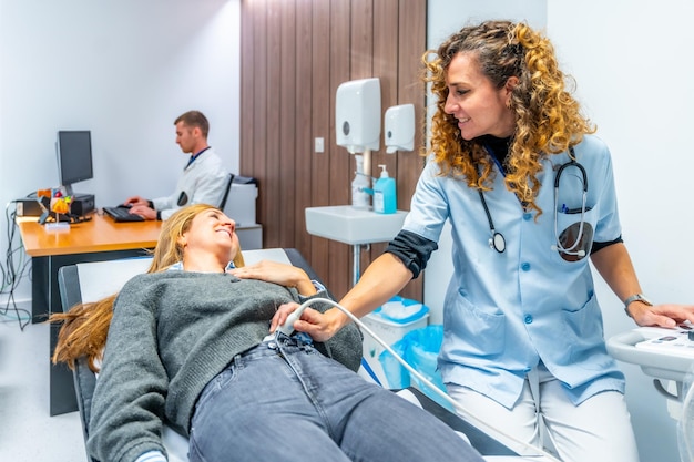 Photo nurse performing an ultrasound to the belly of a woman