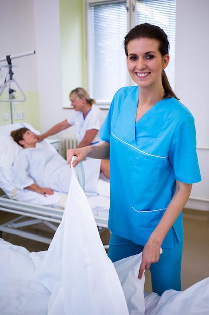 Nurse preparing a bed for a patient