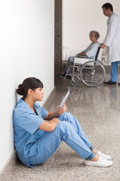 Photo nurse reading sitting on floor