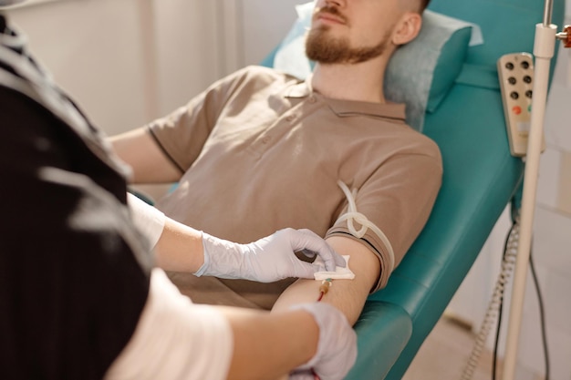 Nurse Removing Catheter from Arm of Her Patient in Clinic