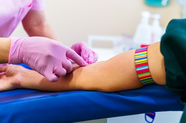 간호사의 손은 실험실 배경 위에 격리되어 혈액을 채취합니다.