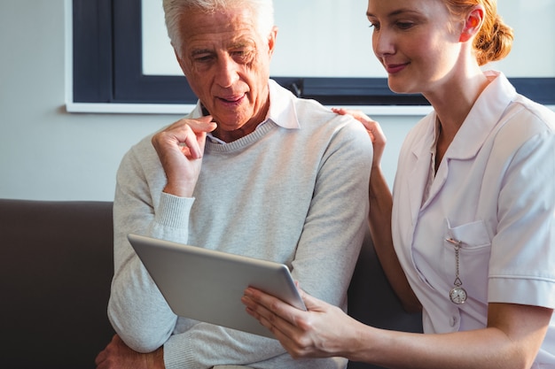 Photo nurse and senior man using a digital tablet