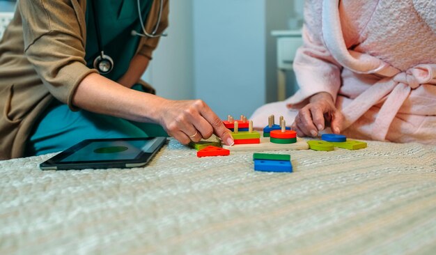 Nurse and senior patient playing with toys in hospital