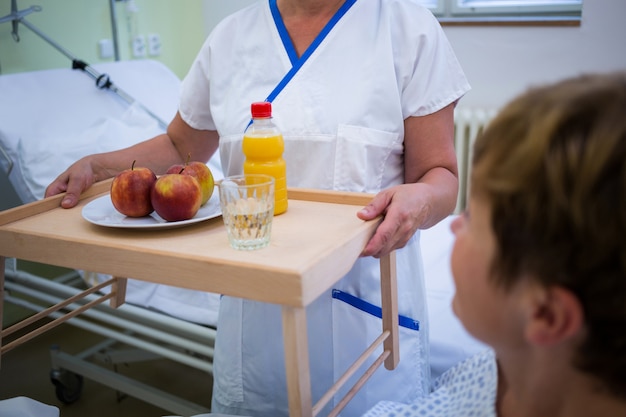 Infermiera che serve una colazione al paziente