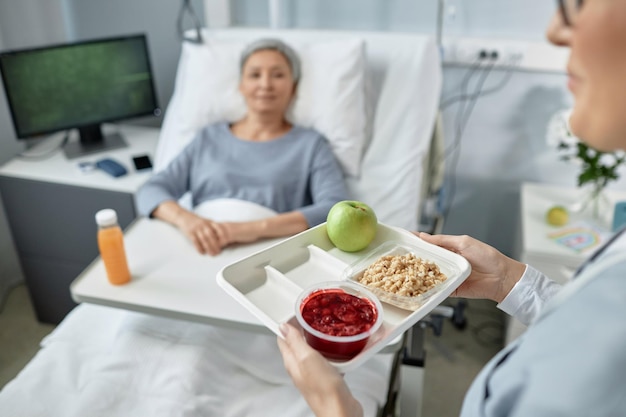 Nurse serving food for sick patient