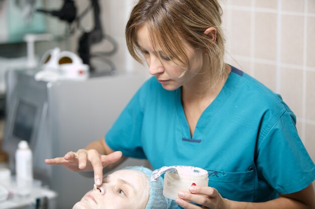 Nurse in a skin clinic applying protective cream