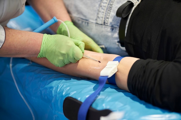 看護師が血液サンプルを採取します。患者から血液サンプルを採取する手袋をはめた医師の手