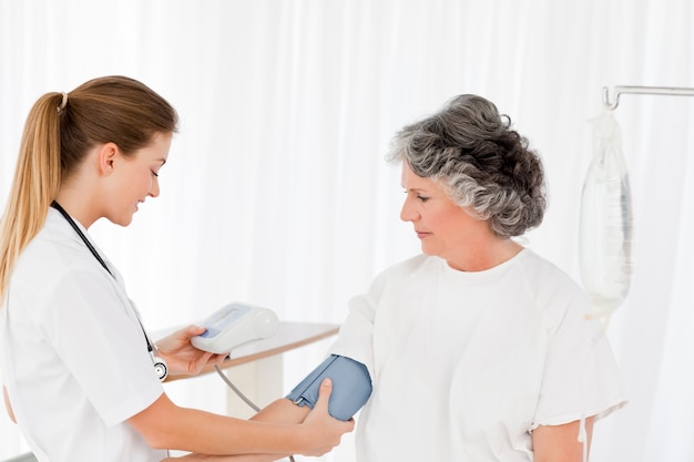 Nurse taking the blood pressure of her patient