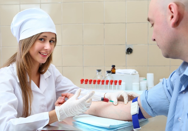 診療所で患者から血液サンプルを採取する看護師