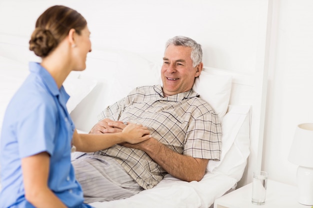 Nurse taking care of suffering senior patient at home