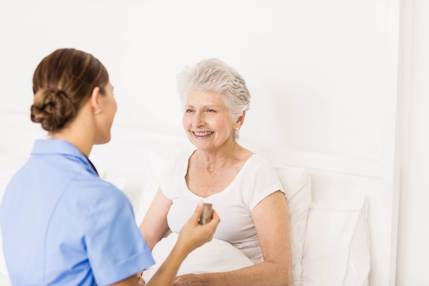 Nurse taking care of suffering senior patient at home