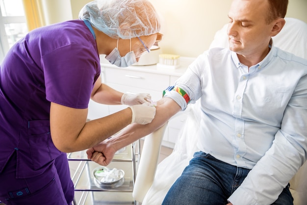 Nurse taking a patient's blood sample at lab | Premium Photo