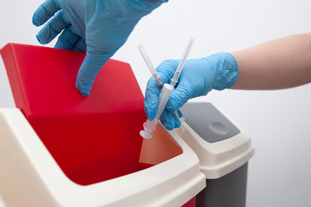 The nurse throw away used syringe into bin